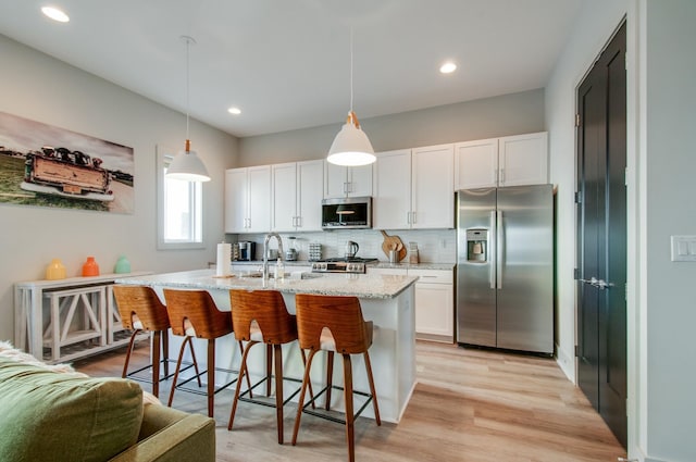 1122 Harmony Way, Nashville, TN 37207 - kitchen with white cabinetry, stainless steel appliances, decorative backsplash, a sink, and light stone counters
