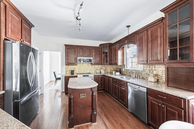kitchen with backsplash, dark wood-style flooring, a sink, and appliances with stainless steel finishes