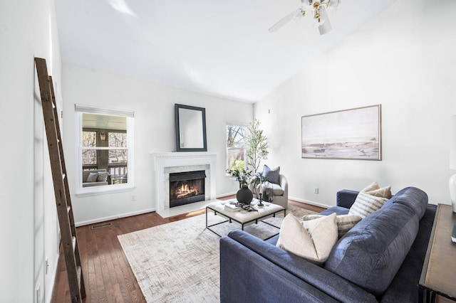 living area featuring visible vents, a fireplace, ceiling fan, dark wood finished floors, and lofted ceiling
