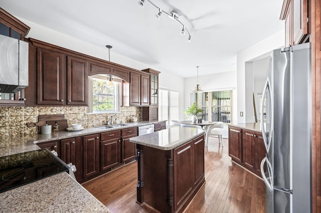kitchen featuring a sink, stainless steel appliances, dark wood-type flooring, and tasteful backsplash