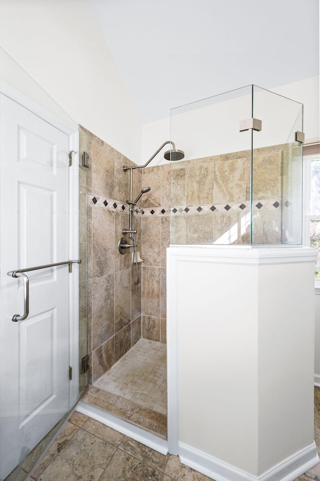full bath featuring vaulted ceiling and tiled shower