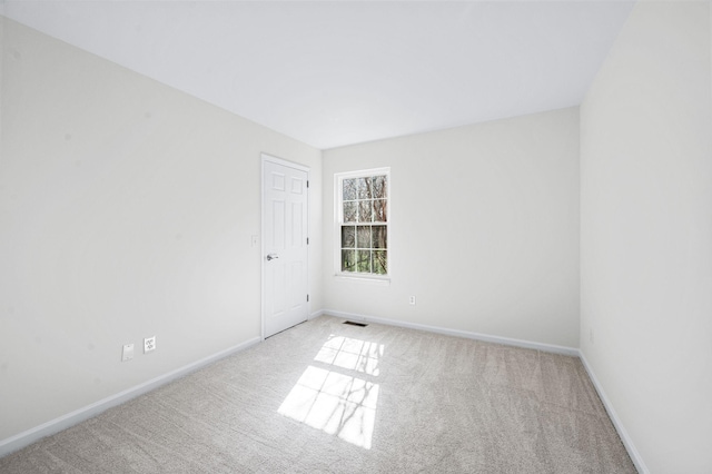 carpeted empty room featuring baseboards
