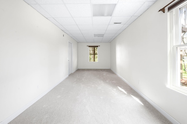 carpeted spare room with baseboards, visible vents, and a paneled ceiling