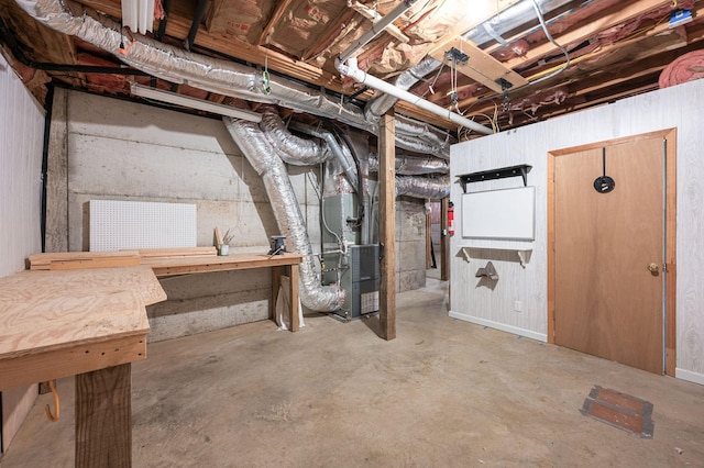 unfinished below grade area featuring heating unit and a workshop area