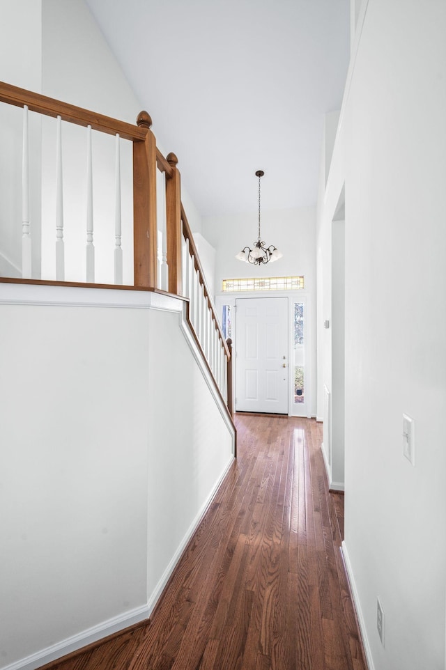 interior space featuring hardwood / wood-style floors, baseboards, stairway, and a chandelier