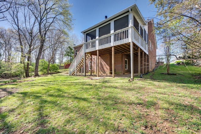 back of property with a lawn, a sunroom, and stairway