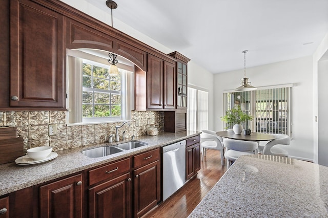 kitchen with a sink, tasteful backsplash, light stone countertops, dishwasher, and dark wood-style flooring