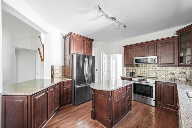 kitchen featuring decorative backsplash, appliances with stainless steel finishes, and dark wood-type flooring