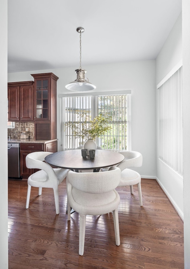 dining space with dark wood-style flooring and baseboards