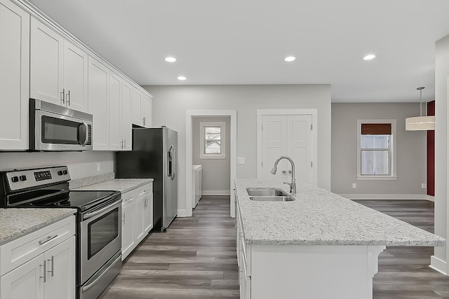 kitchen with a kitchen island with sink, a sink, stainless steel appliances, and plenty of natural light