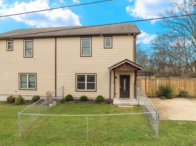 view of front of property with fence private yard, a shingled roof, and a front lawn