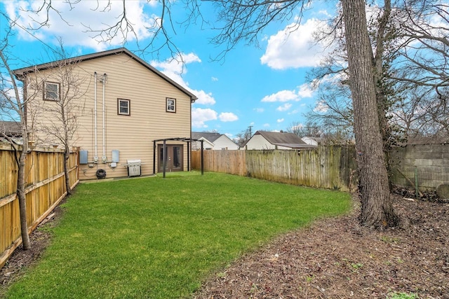 rear view of property with a fenced backyard and a yard