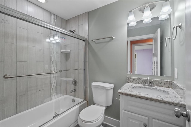 full bath featuring vanity, baseboards, toilet, and bath / shower combo with glass door