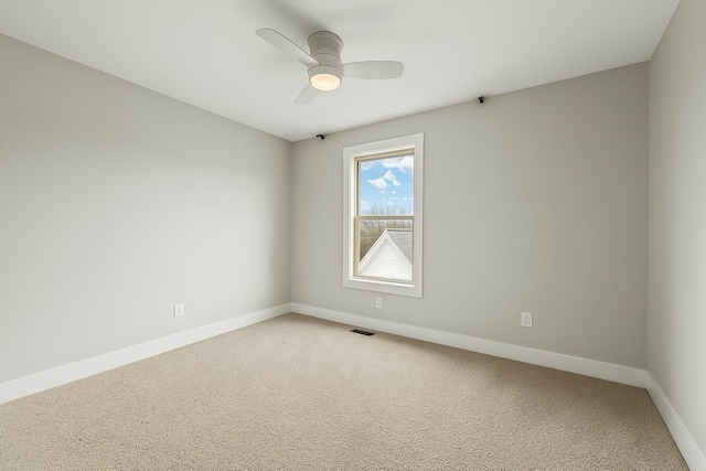 unfurnished room with light carpet, baseboards, visible vents, and a ceiling fan