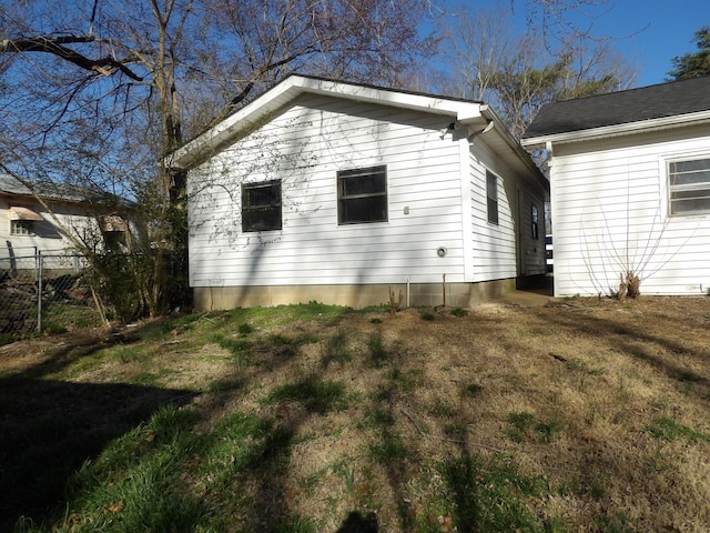 view of property exterior featuring fence and a yard