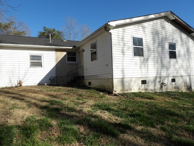 rear view of house with a lawn, crawl space, and entry steps