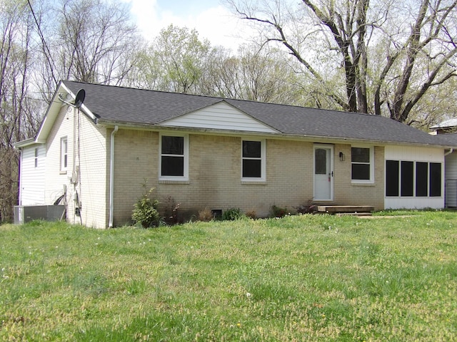 ranch-style home with cooling unit, brick siding, a front yard, and a shingled roof