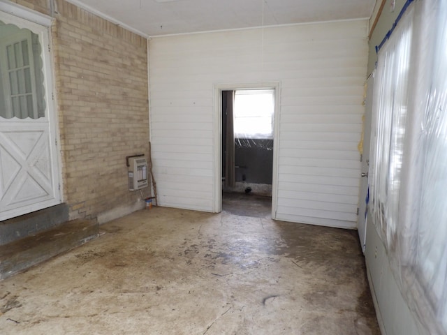 empty room with heating unit and brick wall