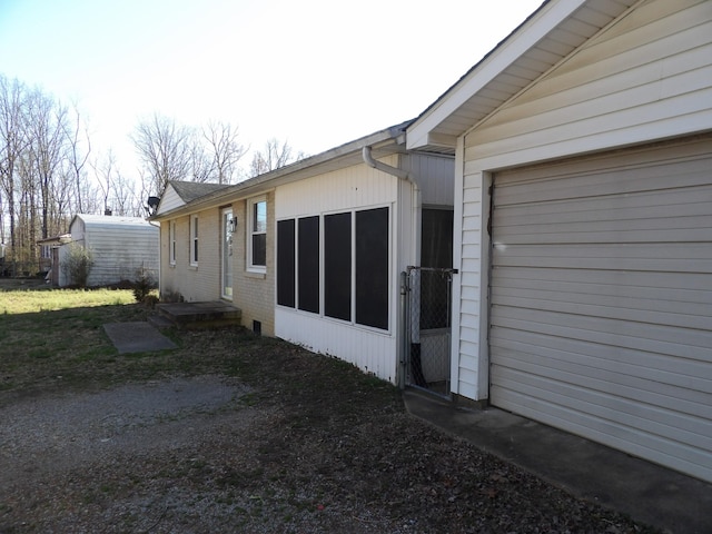 view of side of home featuring a garage and brick siding