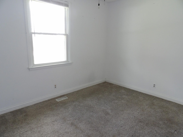 carpeted empty room with baseboards and visible vents