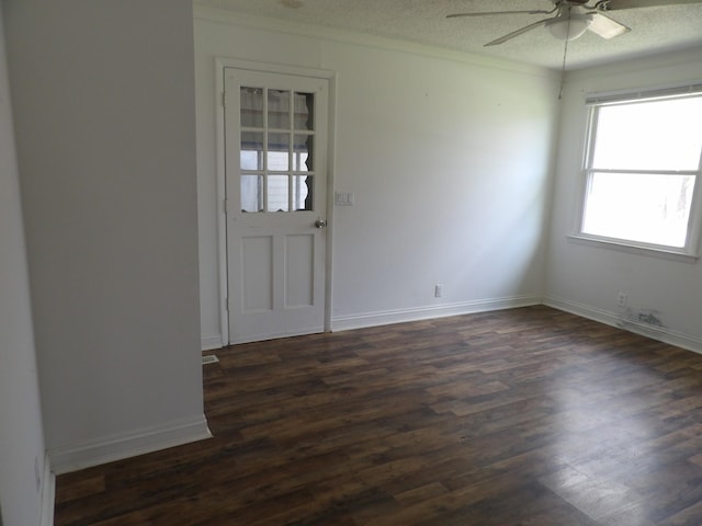 spare room featuring a ceiling fan, dark wood finished floors, baseboards, and a textured ceiling