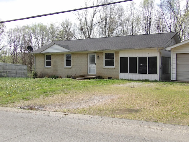view of front facade with brick siding, a shingled roof, and a front yard