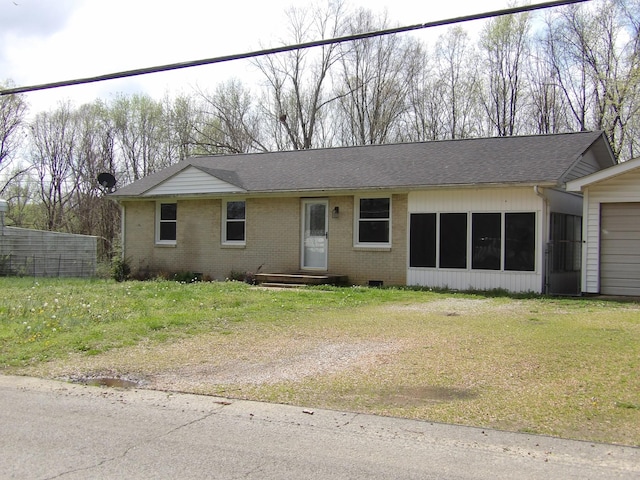 view of front of property featuring brick siding, a front yard, roof with shingles, and an attached garage