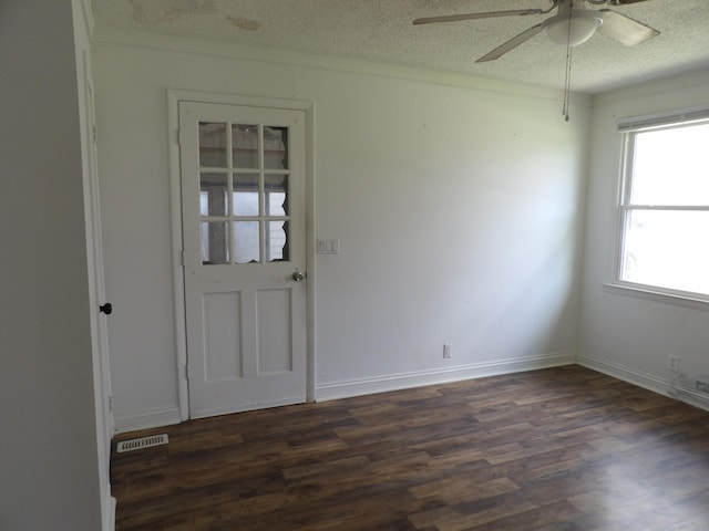 empty room featuring dark wood-style floors, a textured ceiling, ceiling fan, and visible vents