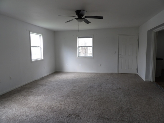 spare room with carpet floors, baseboards, and ceiling fan