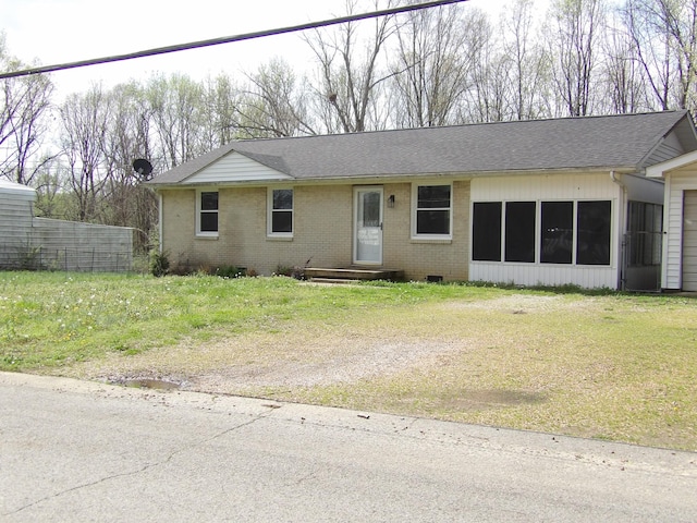 view of front of home with brick siding, a front yard, and a shingled roof