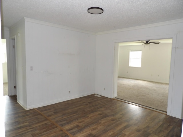 spare room with a ceiling fan, wood finished floors, a textured ceiling, baseboards, and ornamental molding