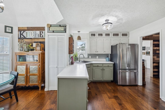 kitchen with light countertops, a sink, dark wood-style floors, freestanding refrigerator, and white cabinets