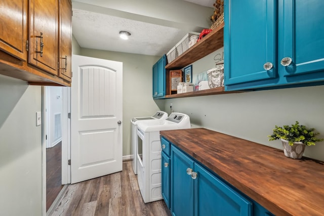 laundry room with washer and clothes dryer, a textured ceiling, dark wood finished floors, visible vents, and cabinet space