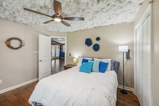 bedroom with baseboards, a closet, wood finished floors, and a ceiling fan