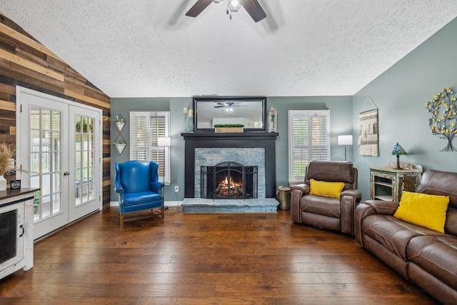 living area with hardwood / wood-style floors, a ceiling fan, a brick fireplace, and lofted ceiling