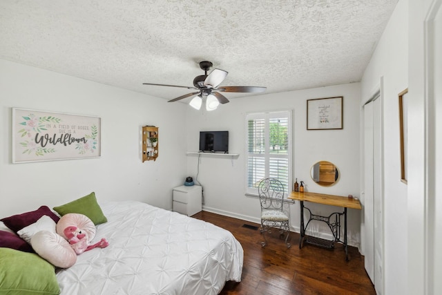 bedroom featuring a textured ceiling, visible vents, hardwood / wood-style flooring, baseboards, and ceiling fan