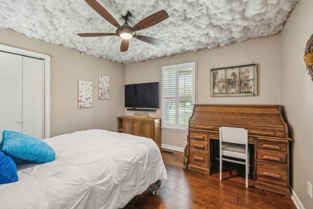 bedroom with a ceiling fan, a closet, baseboards, and wood finished floors