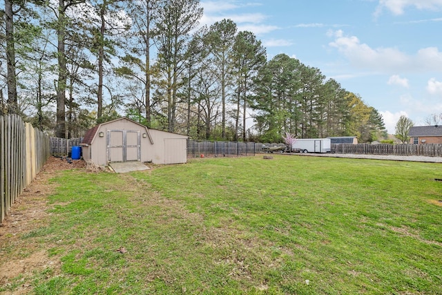 view of yard featuring an outdoor structure, a fenced backyard, and a storage unit