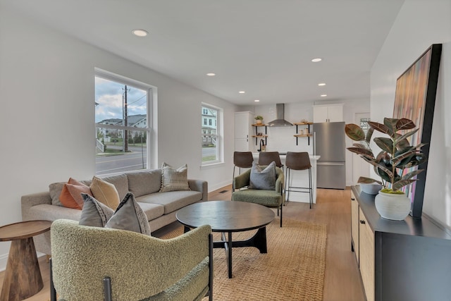 living room with baseboards, recessed lighting, and light wood-type flooring