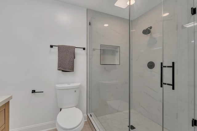 bathroom featuring baseboards, a marble finish shower, toilet, and vanity