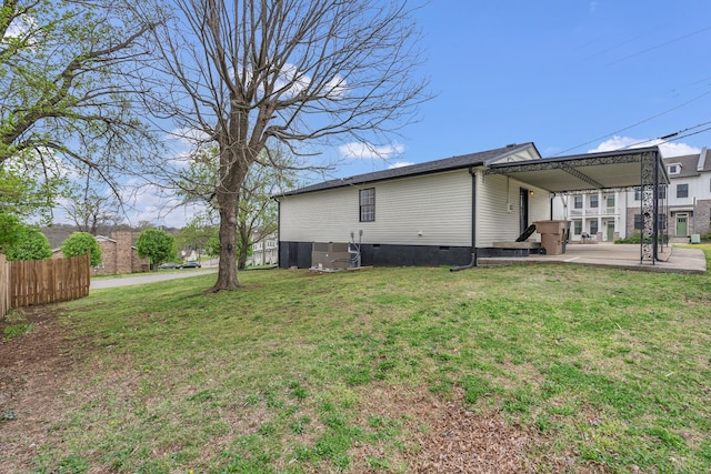 view of property exterior featuring a patio area, fence, a carport, crawl space, and a yard