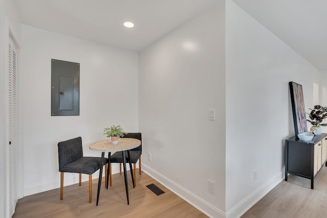 living area with visible vents, electric panel, baseboards, recessed lighting, and light wood-style floors