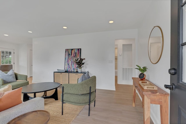 living room featuring baseboards, visible vents, light wood-style floors, and recessed lighting