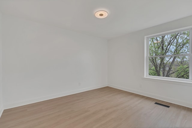 spare room with light wood-style flooring, baseboards, and visible vents