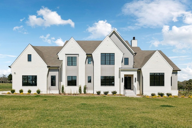 modern farmhouse style home with a chimney and a front yard