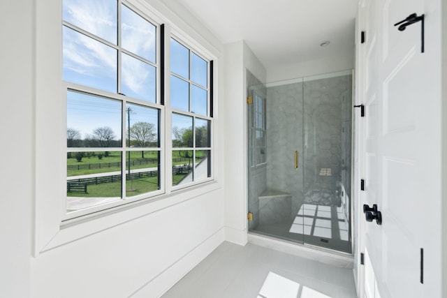 bathroom with tile patterned flooring and a shower stall
