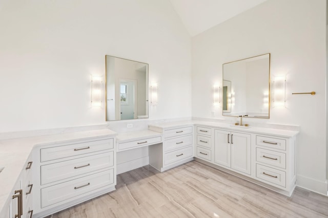 full bathroom with wood finished floors, vaulted ceiling, and vanity