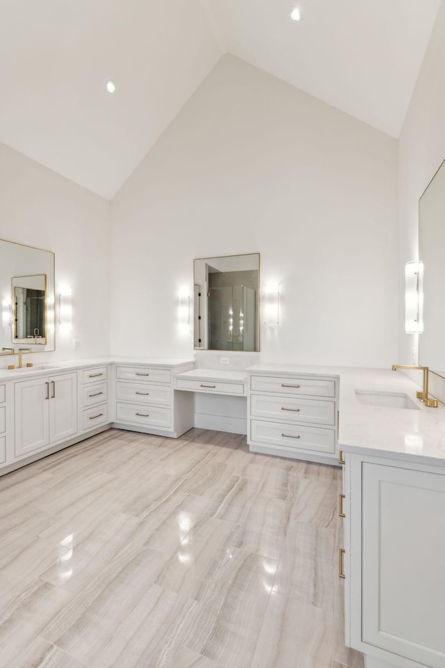 bathroom with vanity and high vaulted ceiling