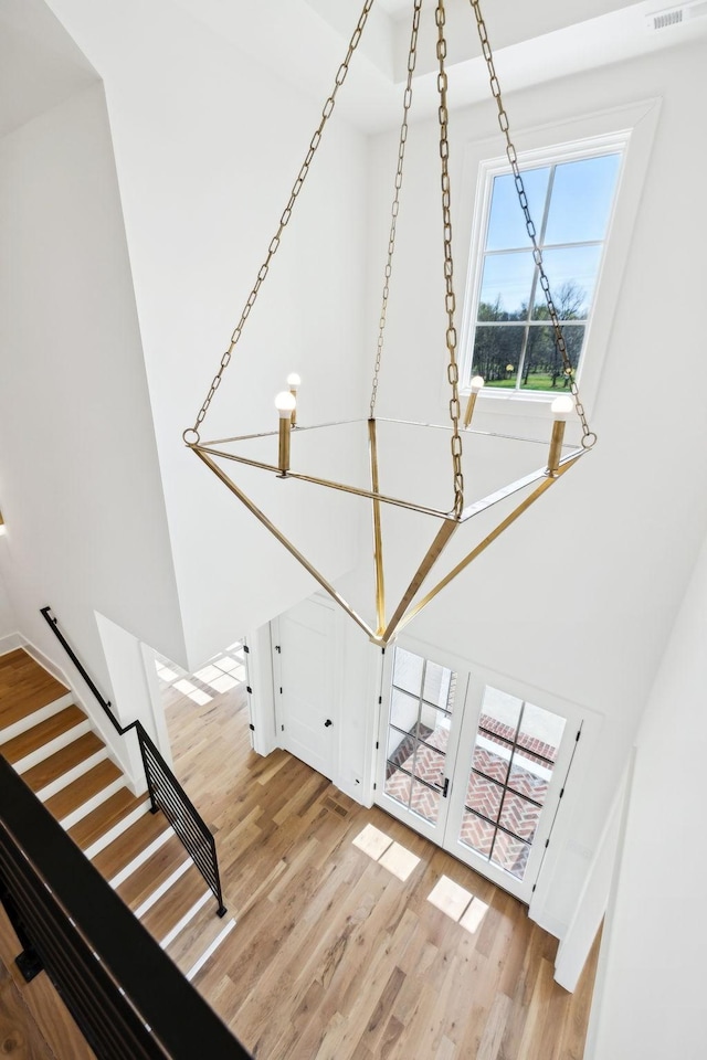 stairway featuring a towering ceiling and wood finished floors