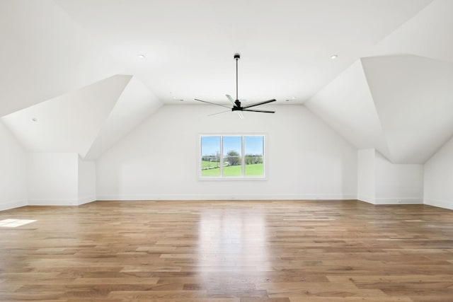 additional living space with baseboards, ceiling fan, vaulted ceiling, and light wood-style floors